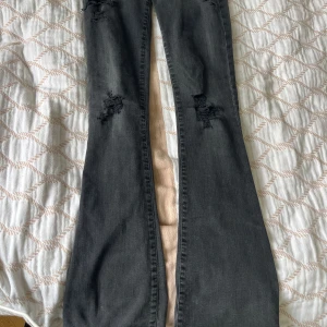 Svarta bootcut jeans - Snygga svarta lågmidjade jeans från Designer’s Remix med bootcut passform och slitna detaljer på låren och knäna. 