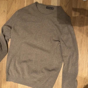 Beige stickad tröja från Oscar Jacobson - Snygg beige stickad tröja från Oscar Jacobson. Den är i bra skick och är i storlek M. Kan tänka mig gå ner i pris lite 