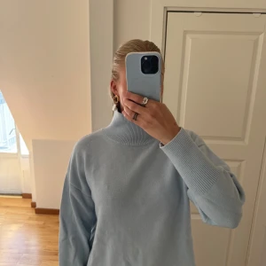 Ljusblå stickad polotröja - Mysig ljusblå stickad polotröja med hög krage och breda ribbade muddar vid ärmslut och hals.🩵🩵