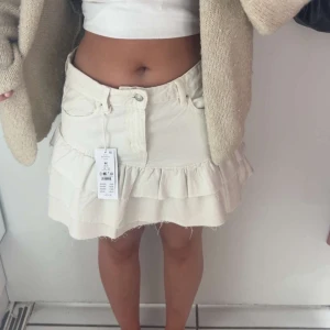 Vit volangkjol i jeans - Intressekoll!! ❣️❣️❣️ Säljer en vit kort jeanskjol med volanger. Aldrig använd, men prislappen är av. 