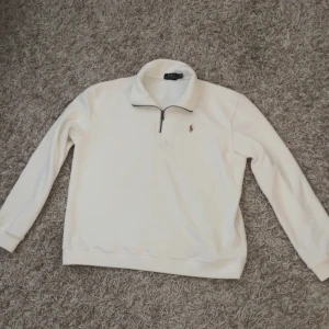 Vit half zip tröja från Polo Ralph Lauren - Snygg vit långärmad tröja från Polo Ralph Lauren. Perfekt för en clean och stilren look. varan är 10/10 skick och passar dig med Stolek M. Har inga husdjur och röker inte så ingen rök lukt eller päls!