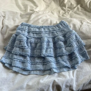 Ljusblå volangkjol - Supersöt ljusblå kjol med flera volanger och ribbad struktur. Kjolen har en kort modell och resår i midjan för extra komfort. Storlek XS