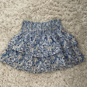 Blåvit volangkjol med mönster - Supersöt kort volang kjol med blått mönster💙 kjolen är i storlek 146/152 men passar xs💗 kontakta om ni har några frågor🥰 