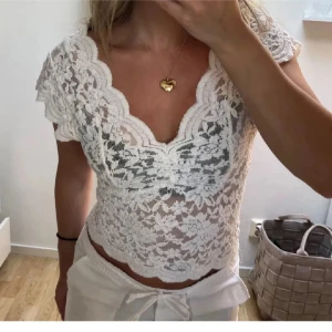 Vit spetsblus med kort ärm - Säljer en söt vit blus i spets med djup v-ringning och korta ärmar. Från Zara! Storlek S