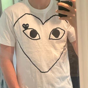 Cdg T-shirt - vit t-shirt från Comme des Garçons Play, i nyskick (endast testad). Jag är 183 och den sitter väldigt bra. Ber om ursäkt för att spegeln var lite smutsig🙏 kolla in min profil för att se ett par feta dondup jeans!