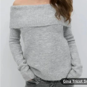 Grå offshoulder tröja från Gina Tricot - Säljer en stilren grå offshoulder tröja från Gina Tricot. Tröjan är stickad och har långa ärmar med en bred krage som kan vikas ner över axlarna. Perfekt för en avslappnad och trendig look.