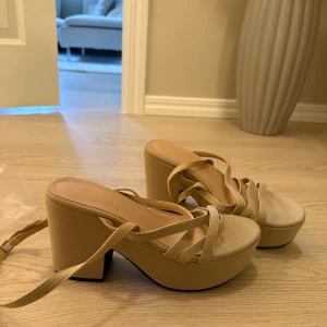Beige sandaler med klack - Oanvända klackar  med remmar. Storlek 39 men passar mer en 38. Dom är verkligen lätta att gå i 