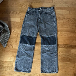  Our Legacy third cut - Säljer ett par grå jeans från Our Legacy med en unik design. Byxorna har mörkare partier på knäna och en klassisk femficksmodell. Perfekta för dig som vill ha något annorlunda i garderoben!