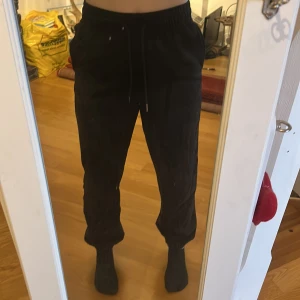 Svarta mjukisbyxor - Säljer ett par svarta mjukisbyxor med elastisk midja. Byxorna har en loose passform och är gjorda i ett mjukt material. Inga fickor bak men har fram. 