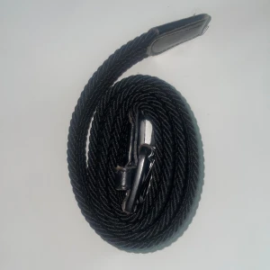 Svart flätat bälte med skinnspänne - Säljer ett stiligt svart bälte med flätad design och ett robost skinnspänne. Perfekt för att ge en klassisk touch till din outfit. Passar till många olika stilar och tillfällen.