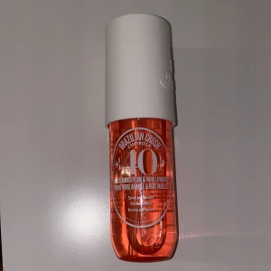 Brazilian Crush Cheirosa 40 - Fräsch och exotisk doftspray från Sol de Janeiro, Brazilian Crush Cheirosa 40. Flaskan är orange med en vit kork och innehåller noter av svart bärnsten och vaniljträ. Perfekt för en tropisk känsla.