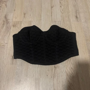 Svart korsett INTE ANVÄNT - Snygg svart korsett från Primark med ett diskret mönster och formande passform. Perfekt för att ge en elegant touch till din outfit. Den har en klassisk design med hakknäppning bak.