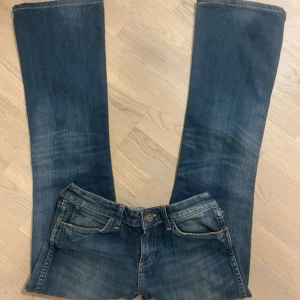 Blå jeans med bootcut - Säljer ett par snygga blå jeans från Wrangler med bootcut-stil. De har klassiska femfickor och en knappgylf. Perfekta för en avslappnad look.