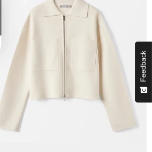 Beige cardigan jacka med dragkedja - Snygg beige cardigan jacka med dragkedja framtill och två stora fickor. Jackan har en klassisk krage och långa ärmar, perfekt för en stilren look.