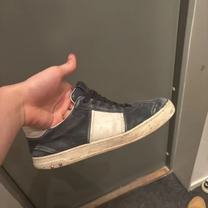 Valentino flycrew - Snygga Valentino sneakers i blått och vitt med snörning. Skorna har en stilren design med en vit panel på sidan och en robust sula. Perfekta för en trendig look. Dåligt skick där av priset, storlek 41 men passar 42/42,5