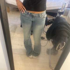 True religion Blå jeans med bootcut - Snygga blå jeans med bootcut-stil och låg midja. Perfekta för en avslappnad look. Klassisk femficksdesign och knappgylf.