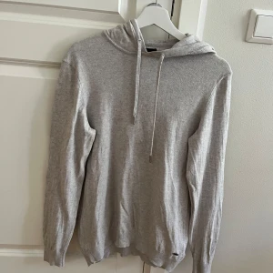 Grå hoodie i marinoull/cashmere - Säljer min hoodie i marinoull och cashmere då den ej kommer till användning samt är den för liten. Cond 9/10 och i Size S. En perfekt tröja nu till våren. Ny pris 90€ Vid fler frågor kontakta mig. Kan gå ner i pris vid snabb affär