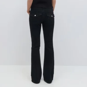 Svarta bootcut jeans - Snygga svarta bootcut jeans med klassisk femficksdesign och silverfärgade knappar. Perfekta för en stilren look. Passar bra till både vardag och fest.