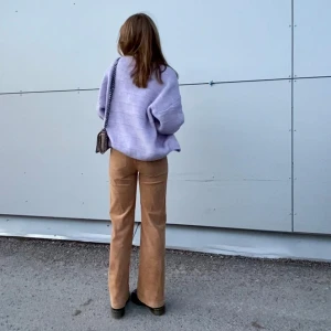 Beige manchesterbyxor från Wera - Snygga beige manchesterbyxor från Wera med medelhög midja (de slutar under naveln) och bootcut-stil. Perfekta för en trendig look med en mjuk och bekväm känsla. Byxorna har en klassisk design med knapp och dragkedja framtill. 📀🎷🌟