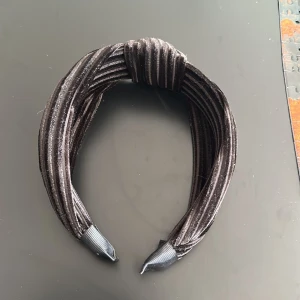 Diadem - Svart diadem med ”knut” uppepå. Aldrig använt eller prövat.