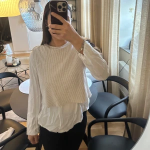 Vit och beige lager-på-lager tröja - Säljer en stilren vit och beige tröja i lager-på-lager stil. Den har en ribbad beige överdel och en vit långärmad skjorta under. Perfekt för en avslappnad men chic look. Passar bra till både jeans och kjol.💗
