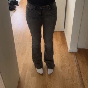 Grå  jeans från Vero Moda - Snygga grå jeans från Vero Moda med en klassisk design. De har en bootcut-stil och är högmidjade för en bekväm passform. Perfekta för en stilren look.