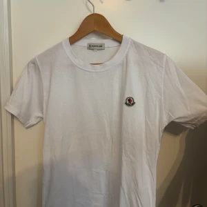 Vit Moncler t-shirt  - Clean vit t-shirt från Moncler med snygg passform. Enkel att matcha med allt i garderoben. 
