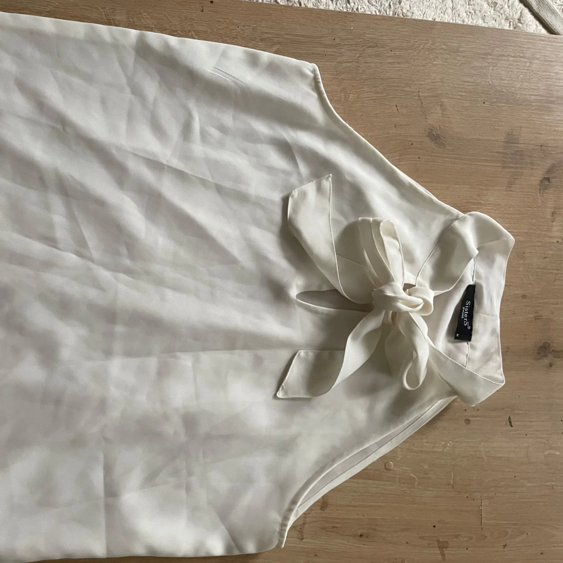 Vit ärmlös blus med knyt från Sisters Point