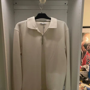 Beige half zip tröja från Zara - Snygg beige långärmad tröja från Zara med krage och half zip-dragkedja framtill. Enkel och stilren design som passar perfekt till jeans eller chinos. Mjuk bomullskänsla och relaxed fit för en chill vibe. Storlek L. Aldrig använd med tagg kvar