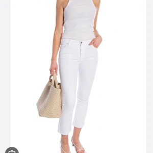 Vita croppade jeans från Ivy - Snygga vita jeans från Ivy (modell Johanna kick flare) med croppad längd. Små fläckar på bakfickan samt att sömmen gått sönder på bakfickan. Storlek 27 