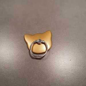 Kattformad ring i guld och vitt - Unik ring i form av ett kattansikte med ena sidan i guld och andra i vitt. Ringen har en cool, modern design och är tillverkad i metall och plast. Perfekt för dig som gillar djur och vill sticka ut med din stil.  Oanvänd så inget att anmärka på