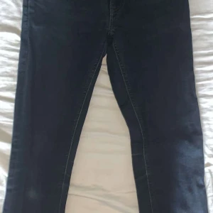 Mörkblå nudie  jeans slim fit - Snygga mörkblå jeans från nudie med klassisk femficksdesign och diskreta sömmar. Jeansen har en slim passform och är tillverkade i mjukt denimtyg som sitter skönt hela dagen. Perfekta för dig som gillar stilrena och tidlösa jeans.
