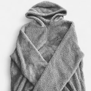 Grå pälsaktig hoodie - Mysig grå teddyjacka med huva och dragkedja framtill. Perfekt för kyliga dagar när du vill hålla dig varm och bekväm. Jackan har en broderad detalj på bröstet.