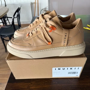 Beige sneakers från Inuikii  - Supersnygga helt oanvända Inuikki för herr. Storlek 43 (men passar också 42,5). Aldrig använda. Kommer med originalkartong (står dock fel storlek kartongen). Köpta i Zürich, Schweiz på Inuikkis huvudkontor (family and friends sale). Nypris 3995:-
