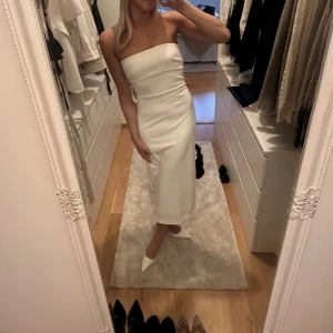 Vit axelbandslös långklänning - Säljer min andra studentklänning som är lång , men passar så fint till andra tillfällen med!! Insydd men sitter som en S då det är min normala storlek 