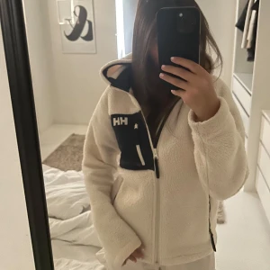 Vit teddyjacka från Helly Hansen - Intresse koll på super snygg jacka från Helly Hansen, inga defekter och användes 1 vår. Köp direkt för 600🤍strl 152 och passar mig som är 156