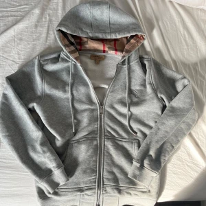 Grå burberry hoddie, stl S - Säljer en riktigt fet hoddie med märket burberry. Den är i storlek S och är riktigt snygg. Det är bara att höra av dig om du är intresserad.