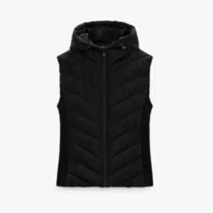 Svart dunväst med huva - Snygg svart dunväst med huva och dragkedja framtill. Västen har ett quiltat mönster i sicksack och är ärmlös med en stilren, sportig look. Perfekt att slänga över en hoodie eller tröja när det är kyligt ute.