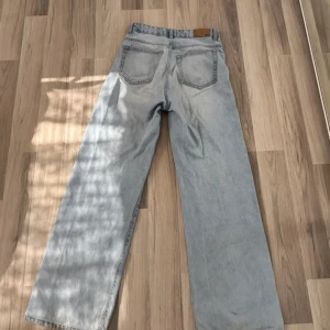 Ljusblå raka jeans från lager 157 - Säljer ett par ljusblå jeans med klassisk femficksdesign och raka, breda ben. Jeansen har hög midja och är tillverkade i mjukt denimtyg. Perfekta för en avslappnad och trendig look.