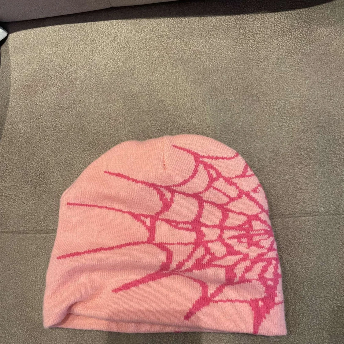Rosa mössa med spindelnätsmönster