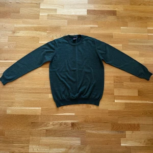 Mörkgrön stickad tröja från Oscar Jacobson - Säljer en stilren mörkgrön stickad tröja från Oscar Jacobson. Inköpt sommaren 2024 och använd ett fåtal gånger i samband med inköpet. Därefter har den förvarats i garderoben.