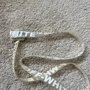 Off-White bälte i vitt - Säljer ett Off-White bälte i transparent plast med vit text och metallspänne. Bältet har den klassiska Off-White-loggan 