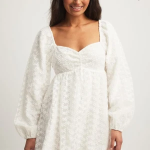 Vit blommig miniklänning med puffärmar från NA-KD - SUPERFIN vit miniklänning från NA-KD med puffiga långa ärmar och blommigt spetsmönster. Helt slutsåld på hemsidan 💕💕 säljer då den TYVÄRR inte passa mig 😭😭