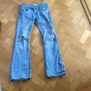 Ljusblå lågmidjade bootcut jeans  - Säljer ett par ljusblå lågmidjade bootcut jeans. Har sprättat upp de längst ner men går att sy upp igen om man vill. 