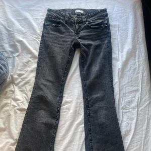 Svarta bootcut jeans från Perfect Jeans/gina tricot  - Säljer ett par svarta bootcut jeans från Perfect Jeans. Jeansen har klassisk femficksdesign, silverfärgade knappar och en snygg tvättad finish. Perfekta för dig som gillar en tidlös look med lite utsvängda ben.