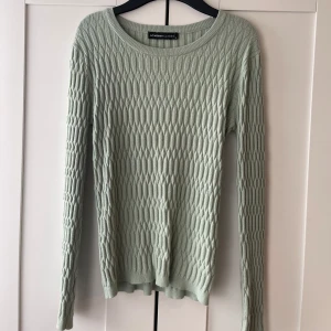 Ljusgrön stickad tröja från LC Waikiki - Säljer en ljusgrön stickad tröja från LC Waikiki. Tröjan har ett unikt strukturerat mönster framtill och ribbad baksida. Rund halsringning och långa ärmar. Perfekt för dig som gillar stilrena och bekväma plagg.
