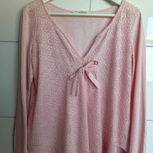 Ljusrosa spetsblus med rosett från Odd Molly - Supersöt ljusrosa blus från Odd Molly med broderad spets framtill och v-ringning i storlek 2. Säljer den då den inte kommer till användning, Perfekt nu till sommaren! 💗💗