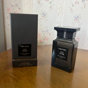 Tom Ford Oud Wood Eau de Parfum 100 ml - Exklusiv parfym från Tom Ford i doften Oud Wood. Flaskan är elegant och svart med en fyrkantig form och matchande svart kartong. Rymmer 100 ml Eau de Parfum och har en lyxig, modern design som passar perfekt på parfymhyllan.