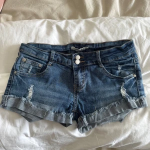 Jeansshorts - Säljer ett par blå jeansshorts från One Love i storlek XS. Lågmidjade och mini .