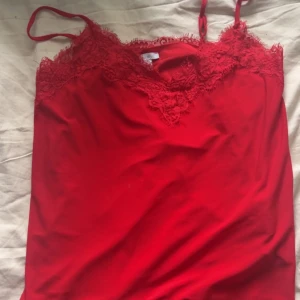 Röd linnetopp med spets  - Säljer detta röda spets linne från new yorker. Säljer för 15kr då jag vill bli av med det. Har inga tecken på användning. Skriv vid frågor💞